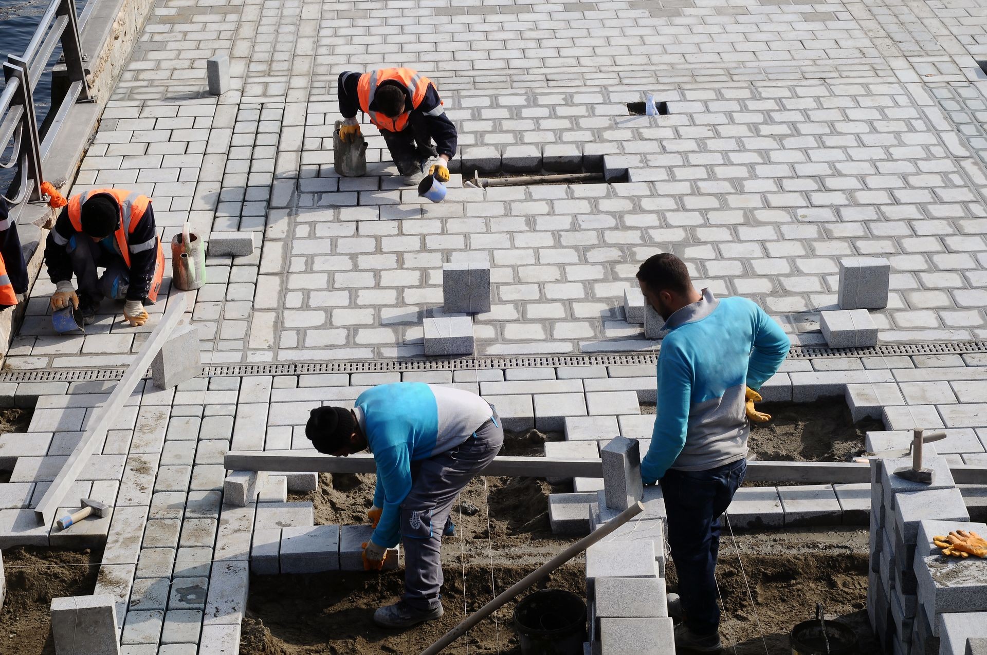 Workers install paving slabs in the courtyard (paving)